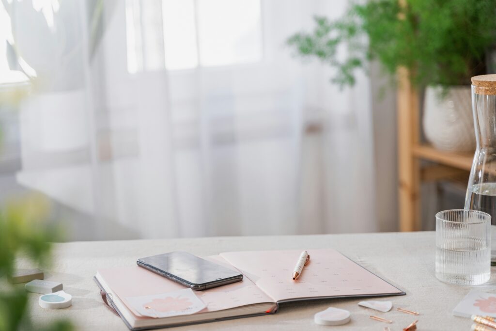 phone and planner sitting on an organized desk